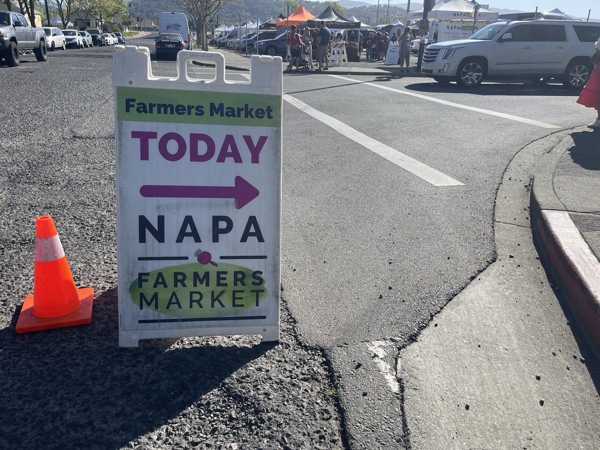 Napa Farmers Market A-frame sign pointing toward the market tents